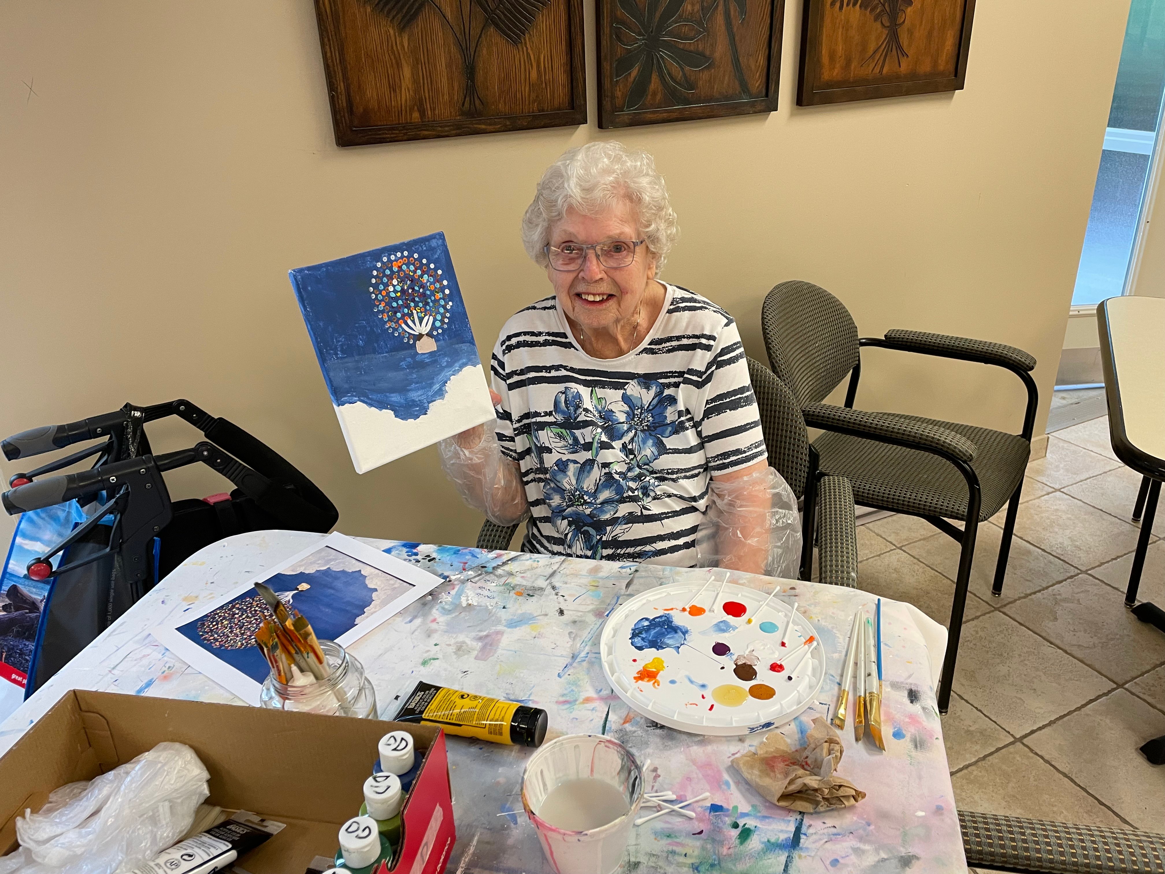 Dorthy showing off her painting of a scene from the movie UP where a house is flying from so many balloons being attached to it.