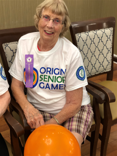 Margie wearing her Origin Senior Games Shirt sporting a winning ribbon